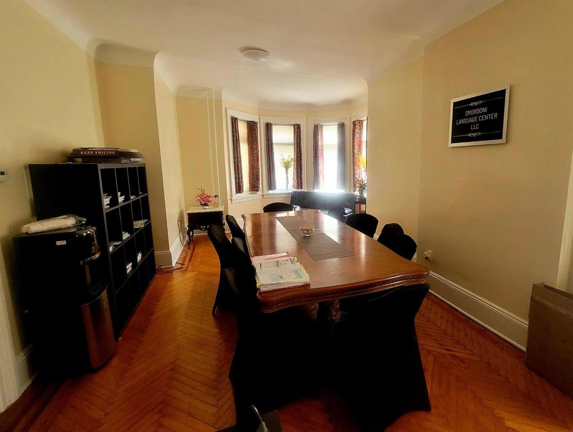 The classroom at 330 Hamilton Ave, with a long wooden table and bay windows